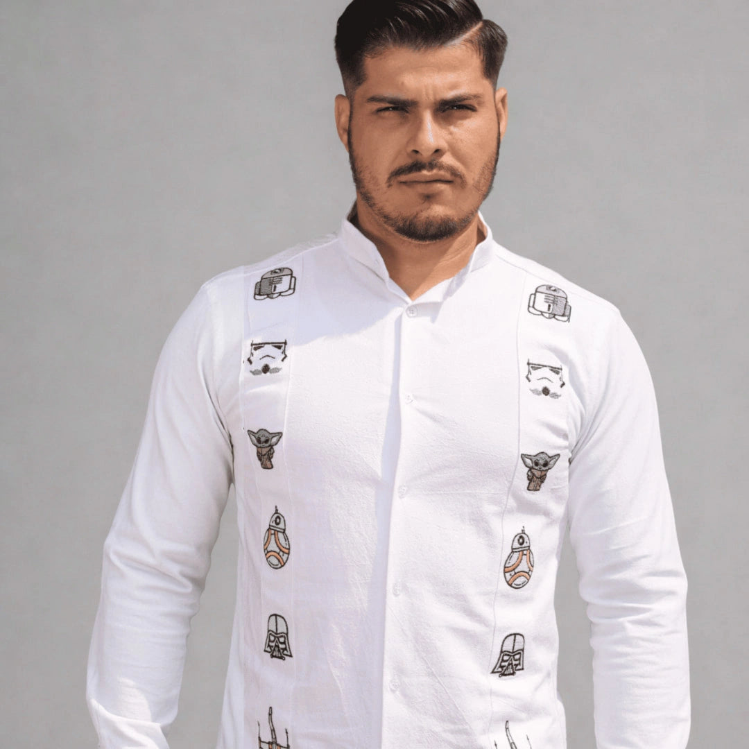 Modelo masculino posando con guayabera blanca de manga larga en lino y algodón de Guayaberas LeMaan, con bordados artesanales inspirados en el equilibrio de una galaxia lejana.
